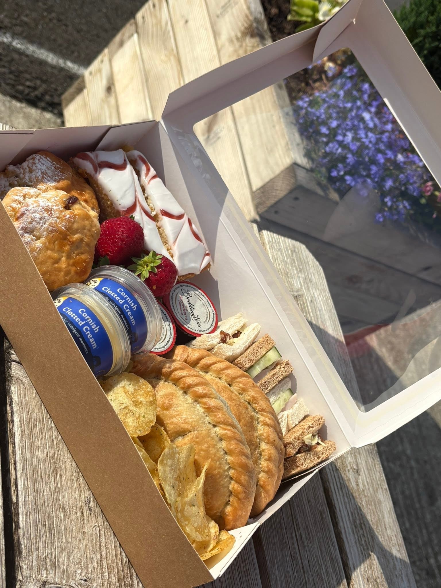 An open Hilltop afternoon picnic box for two with cream tea, strawberries, cakes, sandwiches, pasties and crisps